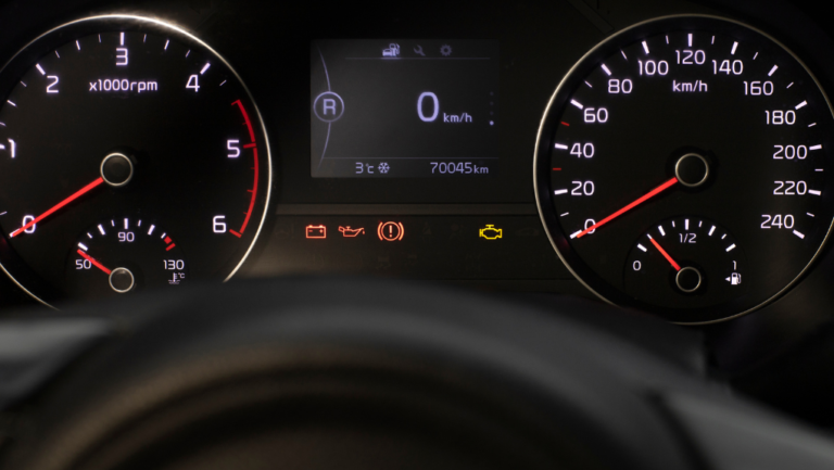 Close-up of an illuminated dashboard with check engine light visible